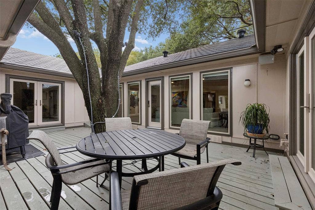 Indoor-Outdoor Connection on Display — Multiple windows and glass doors overlook the courtyard, bringing natural light inside while keeping the outdoor living area visually connected to the home.