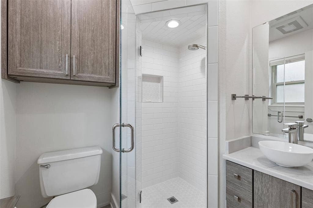 Updated Bath with Frameless Shower — A glass-enclosed shower, clean tilework, updated vanity, and streamlined finishes give this bath a fresh, functional feel.