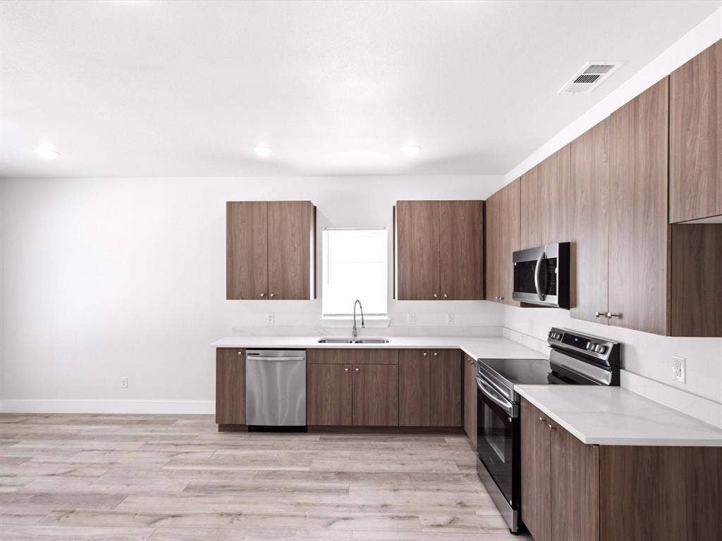 105 Oak Ridge Road, Mabank, TX 75156 Wood-finish flooring, white countertops, built-in stainless steel appliances, and dark wood-finish cabinetry