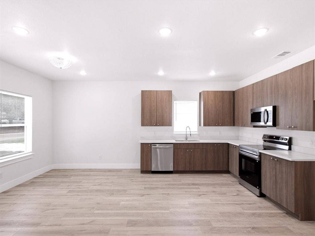 105 Oak Ridge Road, Mabank, TX 75156 Open-concept kitchen with wood-finish cabinetry, stainless steel appliances, white subway tile backsplash, and light wood-finish flooring