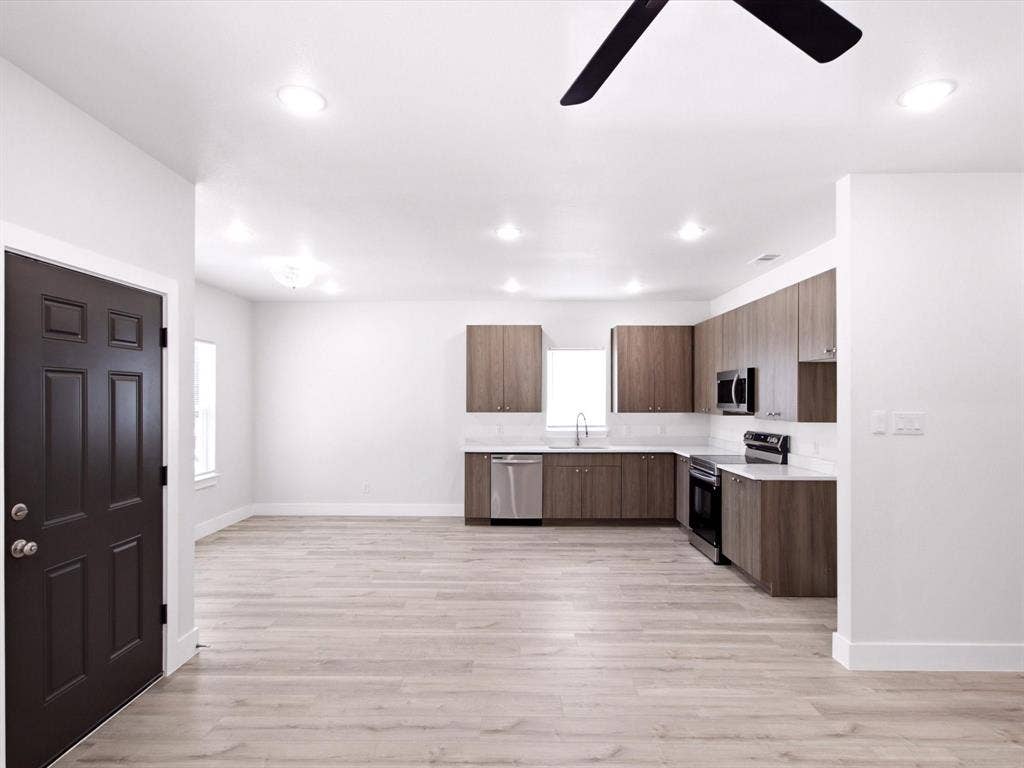 105 Oak Ridge Road, Mabank, TX 75156 Open-concept living space with wood-finish flooring, recessed lighting, and a modern kitchen featuring wood-finish cabinetry, stainless steel appliances, and white countertops