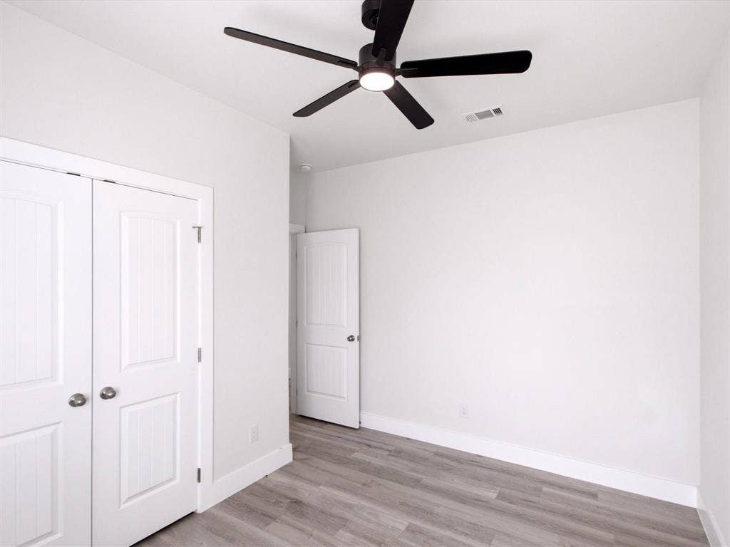 105 Oak Ridge Road, Mabank, TX 75156 Bright interior with wood-finish flooring, white paneled doors, and a ceiling fan with integrated lighting