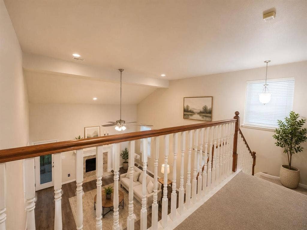 1114 Hidden Creek Drive, Allen, TX 75002 Two-story living area with vaulted ceilings, wood-finish flooring, a fireplace, and a ceiling fan
