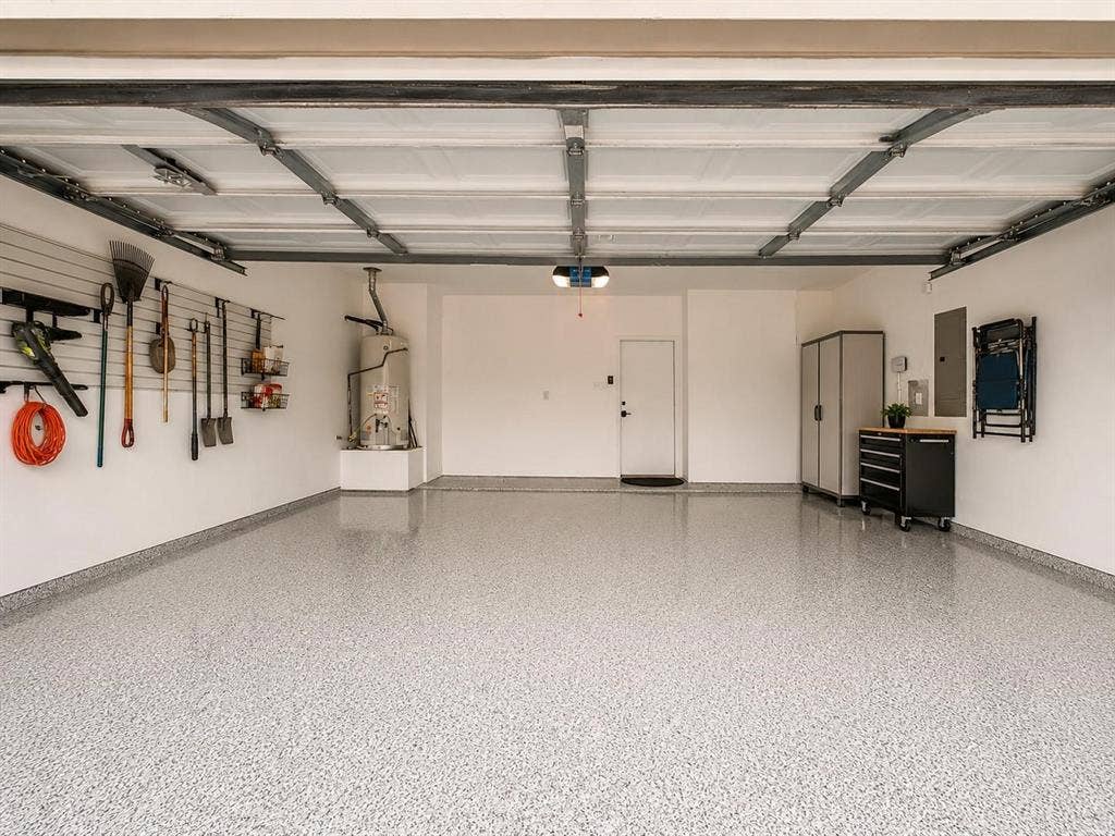 1114 Hidden Creek Drive, Allen, TX 75002 Epoxy flake flooring, overhead garage door system, wall-mounted utility organization, and a water heater installation