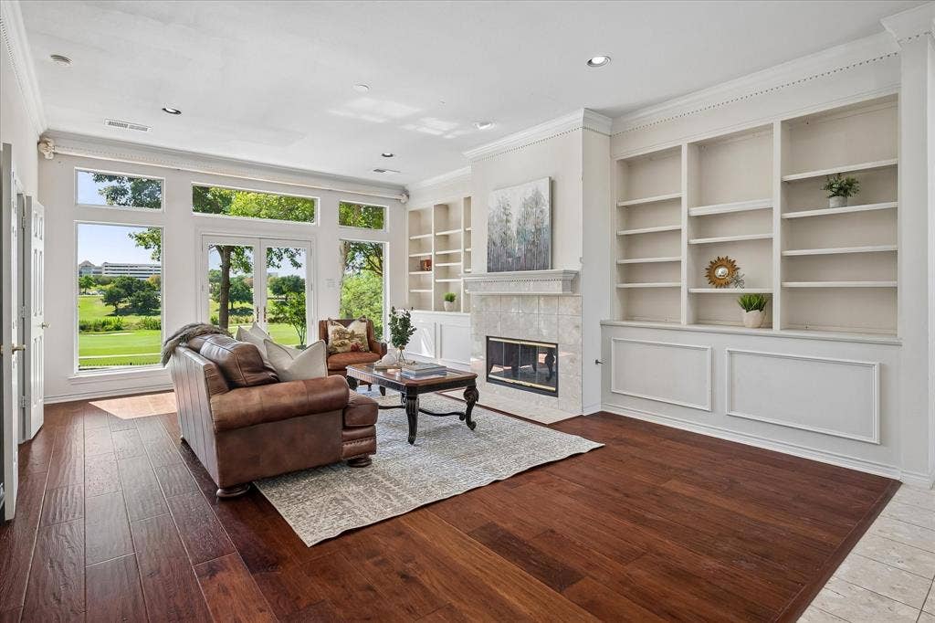 2204 Creekside Circle S, Irving, TX 75063 Wide plank American Hickory floors throughout, built-in shelving, tile-surround fireplace, crown molding, and expansive windows with outdoor access