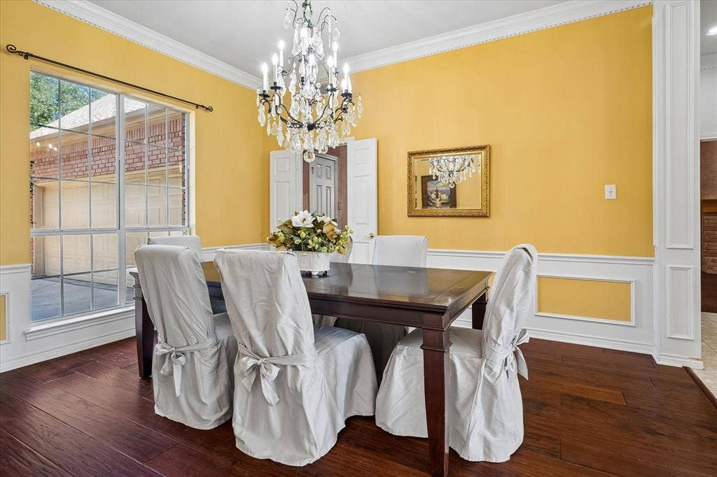 2204 Creekside Circle S, Irving, TX 75063 Hardwood flooring, decorative wainscoting, dental crown molding, and a sparkling crystal chandelier