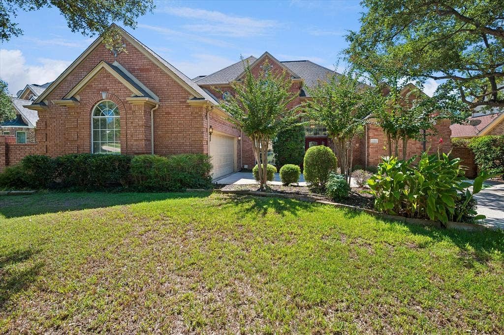 2204 Creekside Circle S, Irving, TX 75063 Brick exterior featuring a gabled roofline, arched window, and attached garage