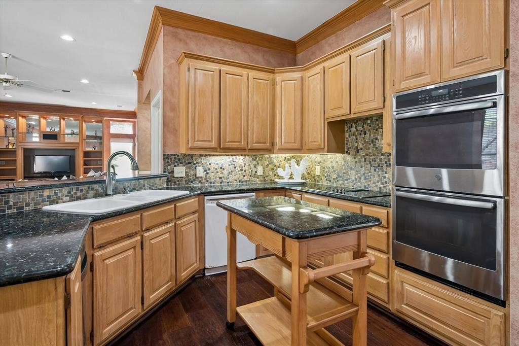 2204 Creekside Circle S, Irving, TX 75063 `Decorative tile backsplash sets off this chefs kitchen with stainless double ovens, top is convection and bottom conventional. Also featuring induction cooktop with down draft and 3 compartment kitchen sink