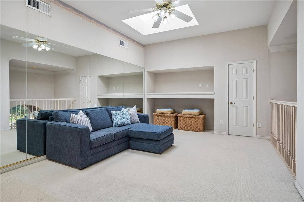 2204 Creekside Circle S, Irving, TX 75063 Recessed ceiling skylights, ceiling fan with integrated lighting, full-wall mirrors, built-in shelving, and neutral carpeting with walk out attic access