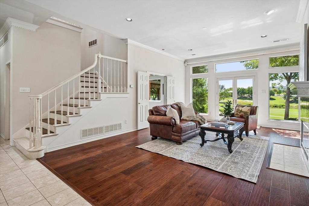 2204 Creekside Circle S, Irving, TX 75063 Expansive living area with rich and durable American Hickory hardwood, a grand staircase with wood steps, white balusters, and dental molding are the backdrop for the star of this home, the incredible views!!