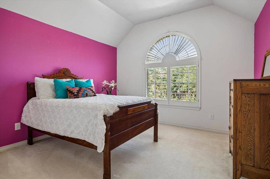 2204 Creekside Circle S, Irving, TX 75063 Guest bedroom with arched window with plantation shutters, vaulted ceiling, and carpeted flooring with en suite bath