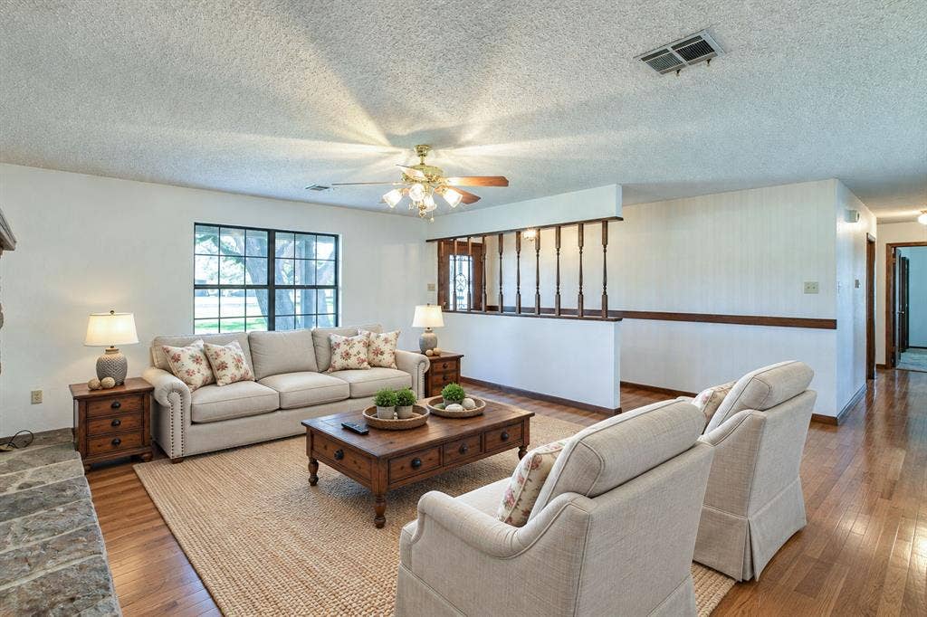 118 Spring Lake Drive, Lacy Lakeview, TX 76705 Wood-finish flooring in living area and hall, complemented by a stone hearth