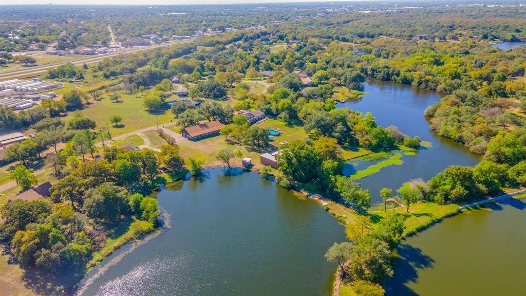 118 Spring Lake Drive, Lacy Lakeview, TX 76705 Expansive property featuring multiple bodies of water, extensive tree coverage, and visible structures