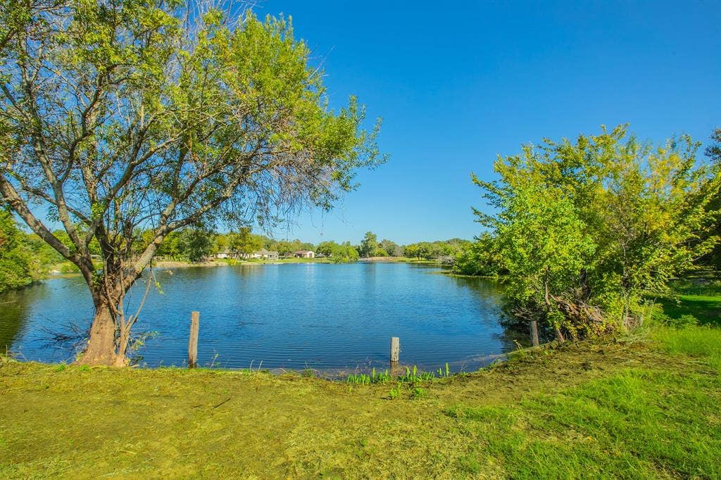 118 Spring Lake Drive, Lacy Lakeview, TX 76705 Expansive waterfront featuring a calm body of water, and mature trees framing the shoreline. Property line extends into the lake. Should be confirmed by a survey.