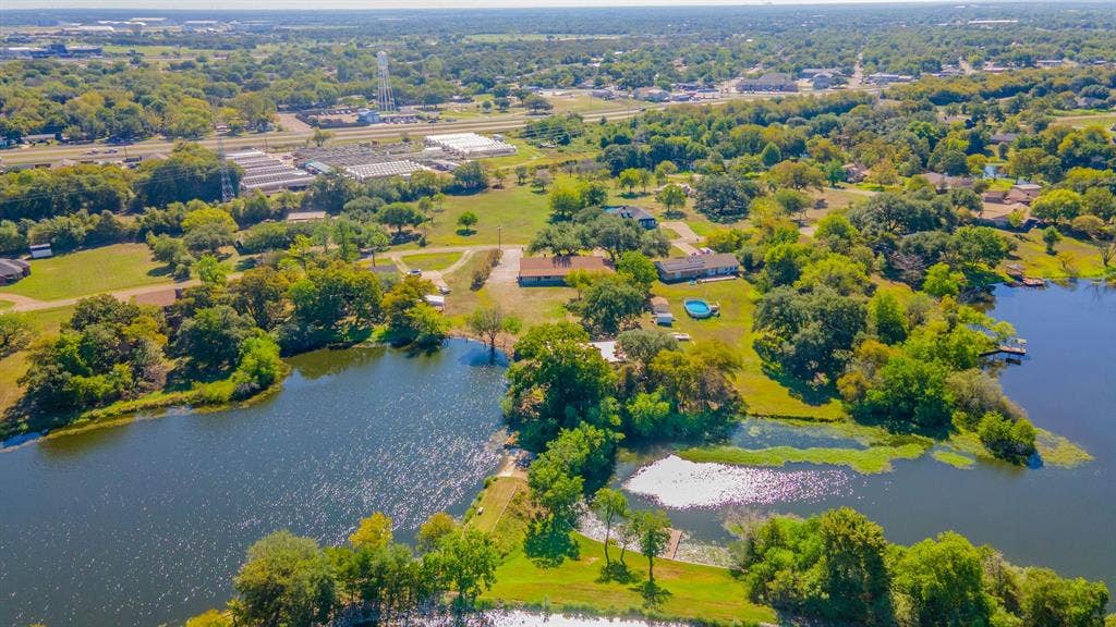 118 Spring Lake Drive, Lacy Lakeview, TX 76705 Expansive property featuring a tranquil lake, multiple residential structures, and mature trees