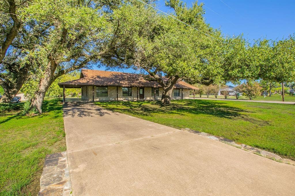 118 Spring Lake Drive, Lacy Lakeview, TX 76705 Stone exterior with a covered porch,, a concrete driveway on this side leads to a covered carport which connects to the covered wrap around porch! That's right. There are 2 driveways!
