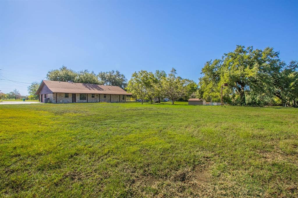 118 Spring Lake Drive, Lacy Lakeview, TX 76705 Expansive lawn. Property is 1.58 acres according to MCAD. Buyers confirm! This view is from the shore line of the lake looking back at the home.