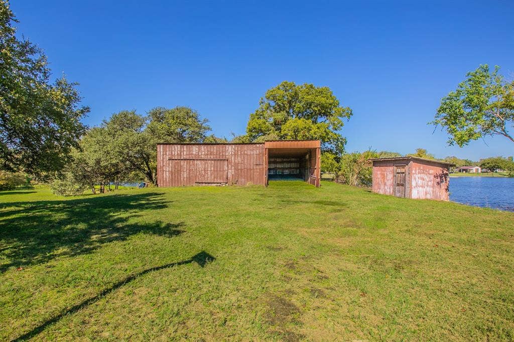 118 Spring Lake Drive, Lacy Lakeview, TX 76705 Double level metal shop with RV parking space and well house. See the next 2 pics for AI renderings of other possible uses for this spot!!