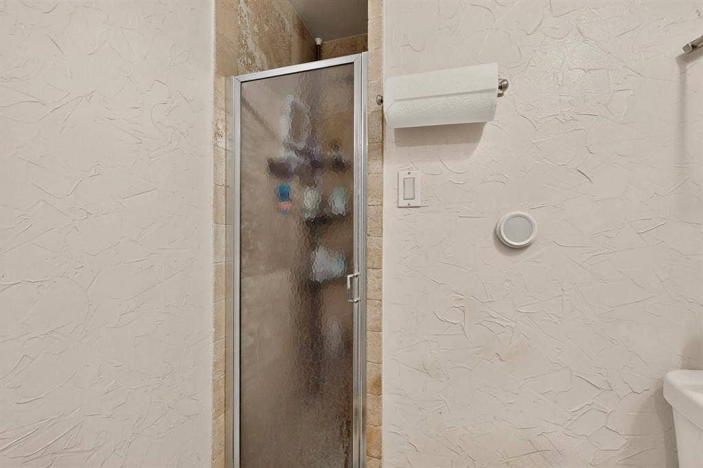 Shower enclosure with a frosted glass door and metal frame