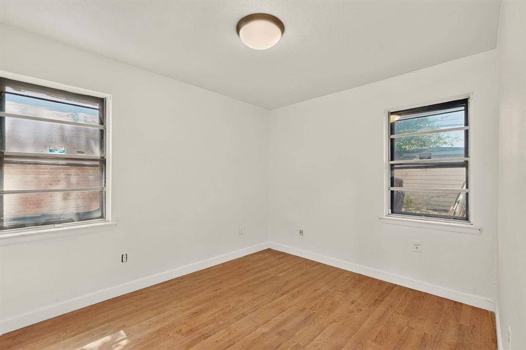 Ceiling light fixture, wood-finish flooring, and white painted walls