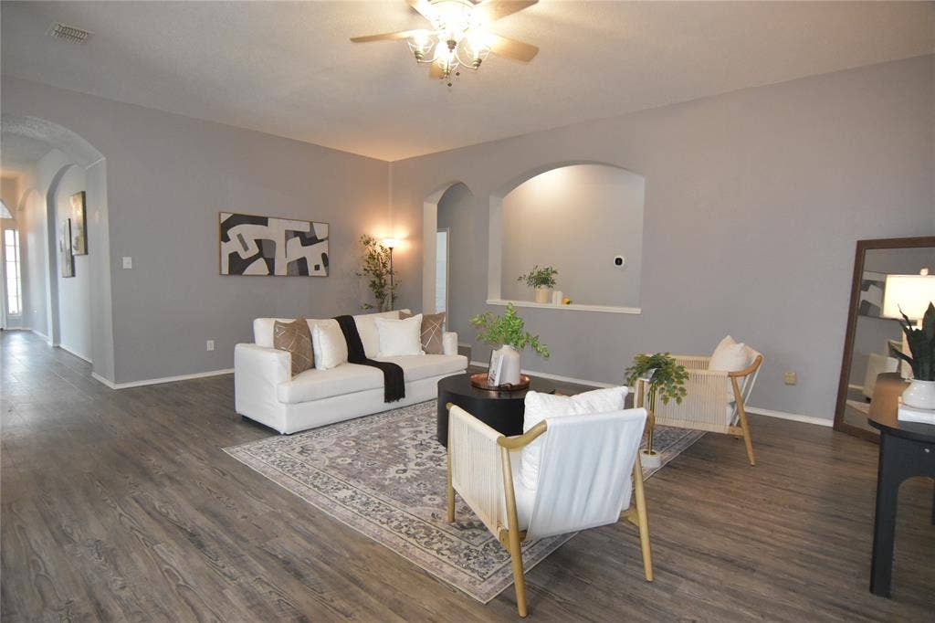 215 Longhorn Trail, Grand Prairie, TX 75052 Wood-finish flooring, recessed wall niche, arched doorways, light gray walls, and a ceiling fan with integrated lighting