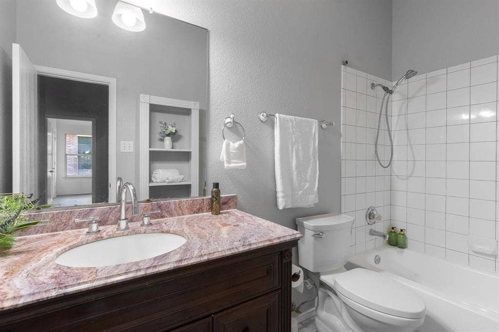 215 Longhorn Trail, Grand Prairie, TX 75052 Vanity with an oval undermount sink, multi-tone countertop, and chrome faucet