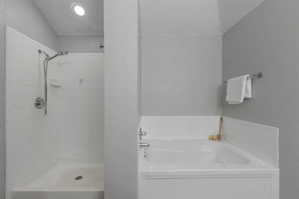215 Longhorn Trail, Grand Prairie, TX 75052 Recessed ceiling lighting, white subway tile shower surround, chrome shower fixtures, built-in bathtub, and chrome towel bar