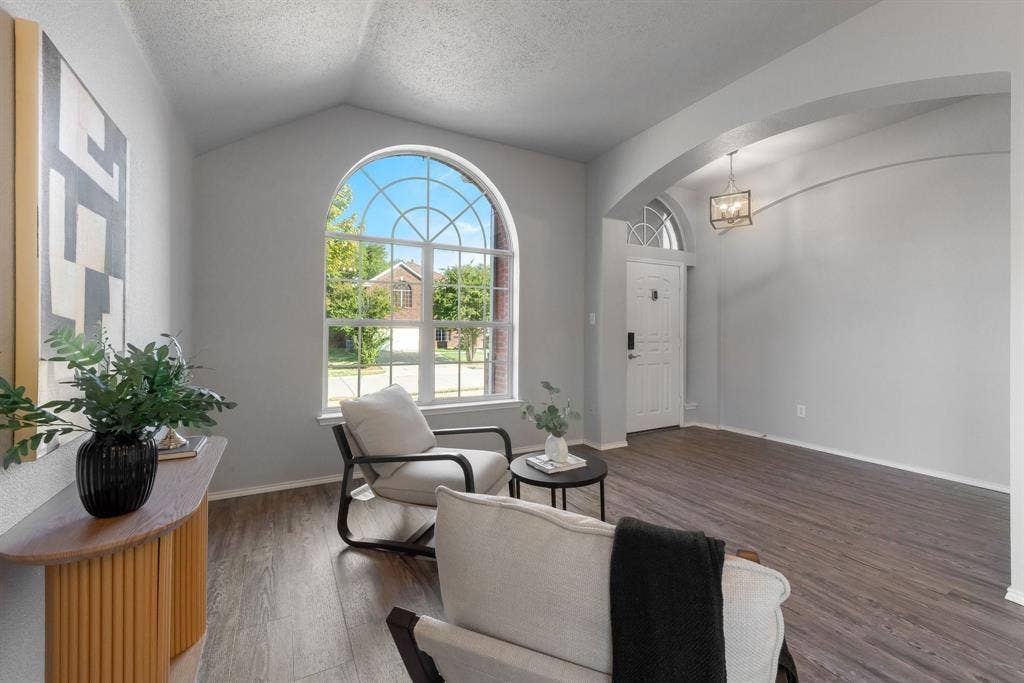 215 Longhorn Trail, Grand Prairie, TX 75052 Vaulted ceiling with an arched window, wood-finish flooring, recessed entry, and an overhead light fixture