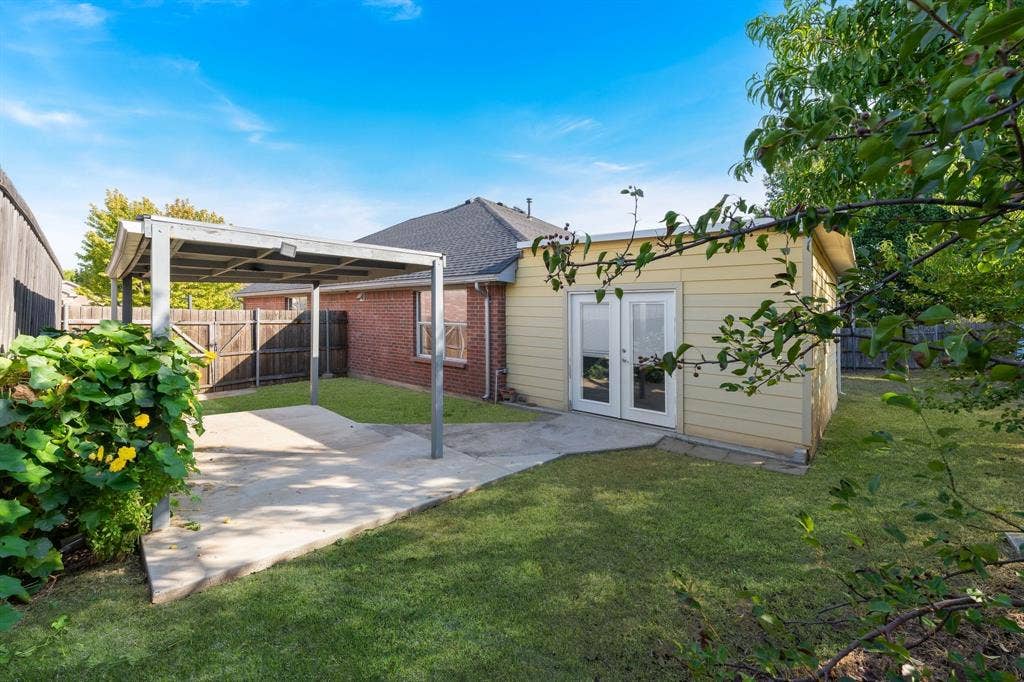 215 Longhorn Trail, Grand Prairie, TX 75052 Detached structure with double glass doors, a covered patio, and a manicured lawn