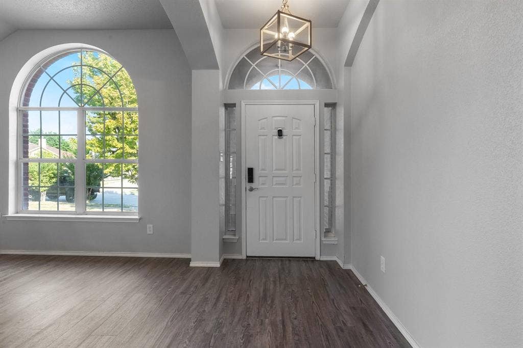 215 Longhorn Trail, Grand Prairie, TX 75052 Arched transom window above the entry door with sidelights, wood-finish flooring, and an arched window