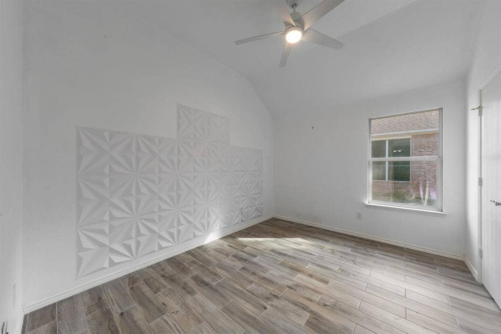 215 Longhorn Trail, Grand Prairie, TX 75052 Vaulted ceiling, wood-finish flooring, ceiling fan with integrated lighting, window, and textured wall panels