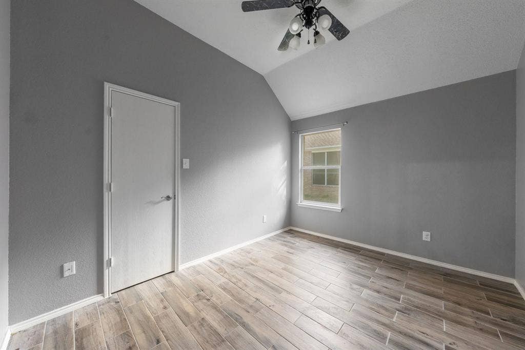 215 Longhorn Trail, Grand Prairie, TX 75052 Wood-finish flooring, vaulted ceiling, and a ceiling fan with integrated lighting