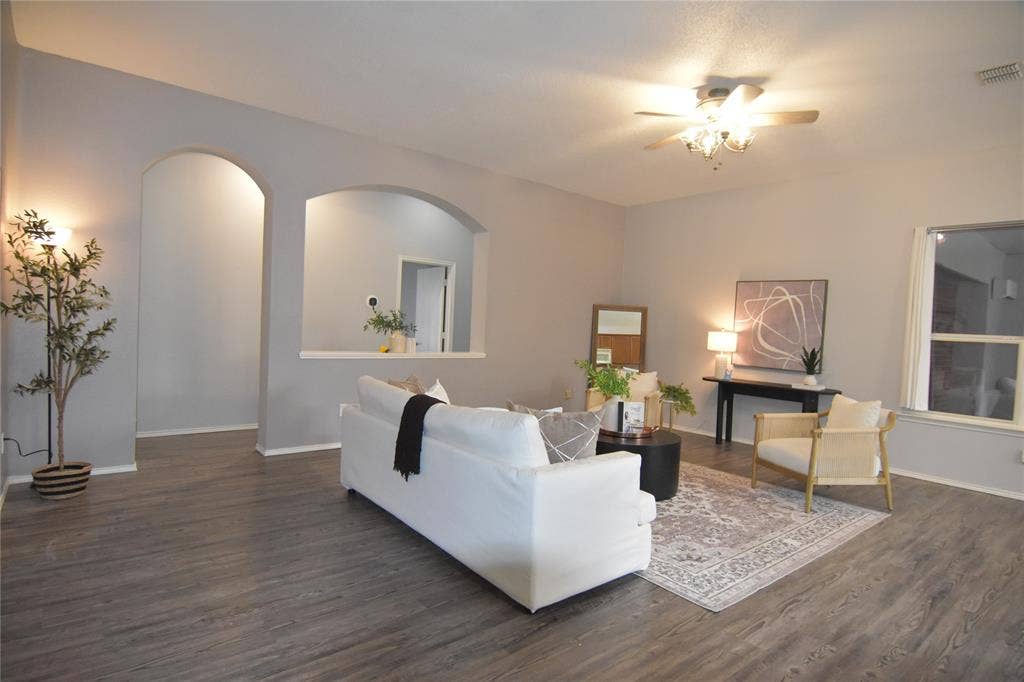 215 Longhorn Trail, Grand Prairie, TX 75052 Recessed archways, wood-finish flooring, ceiling fan with integrated lighting, window with white trim, and light gray wall paint