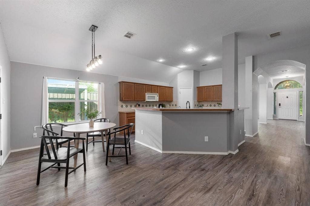 215 Longhorn Trail, Grand Prairie, TX 75052 Kitchen and dining area featuring wood-finish flooring, recessed lighting, and a kitchen island with built-in cabinetry