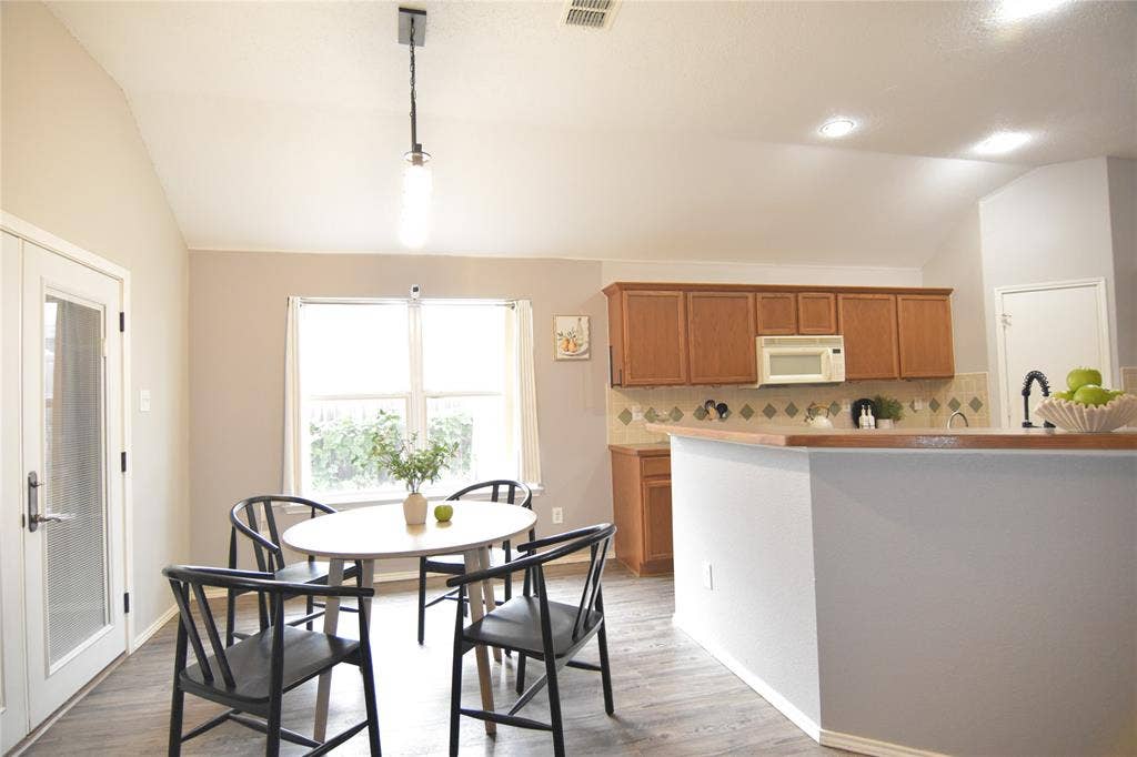 215 Longhorn Trail, Grand Prairie, TX 75052 Vaulted ceiling with recessed lighting, wood-finish flooring, kitchen with wood cabinetry, tiled backsplash, and a window for natural illumination