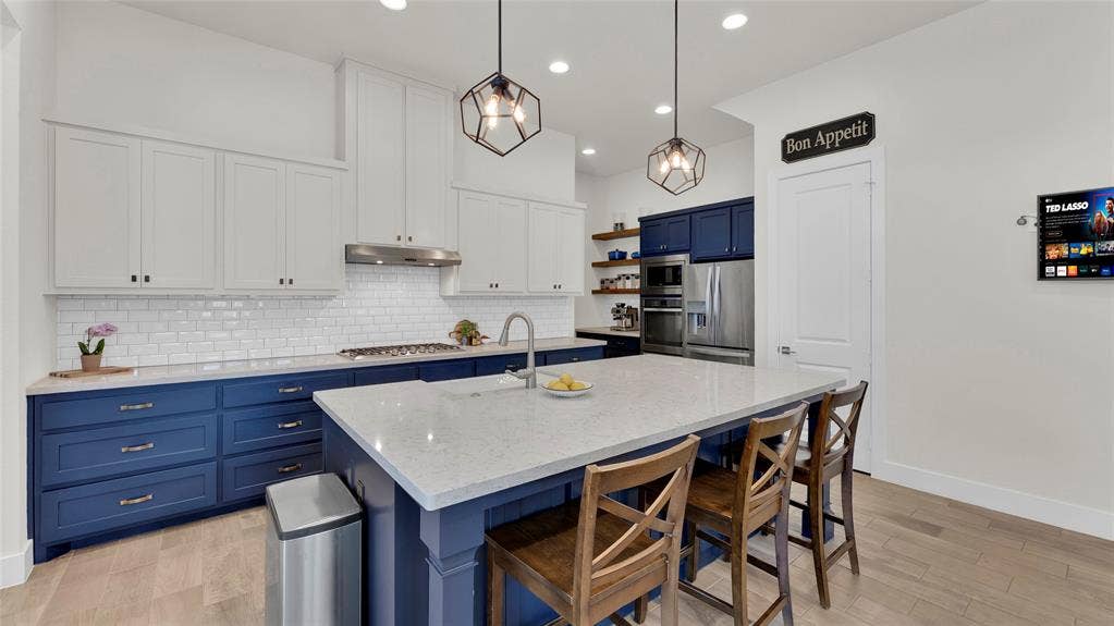 5925 Mayhew Court, McKinney, TX 75070 Beautiful quartz countertops, Viking cooktop, updated dishwasher, lower cabinets replaced with soft close doors. Cabinet doors under breakfast bar open for additional storage.