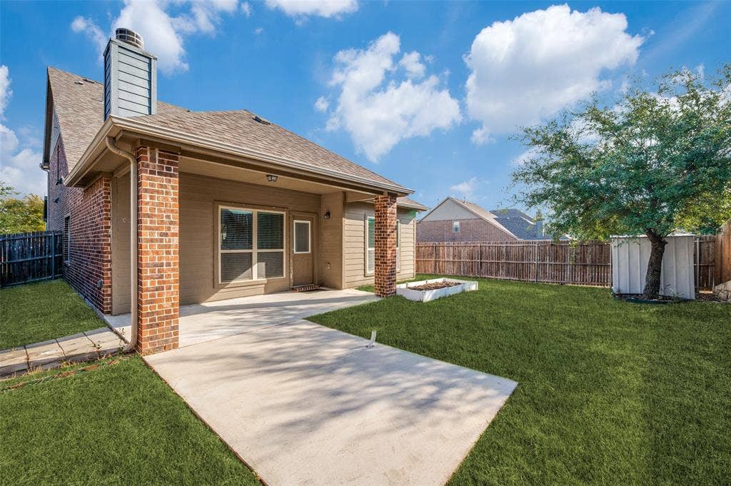 9801 Moccasin Creek Lane, McKinney, TX 75071 Expansive backyard featuring a concrete patio, brick columns, mature tree, and privacy fencing