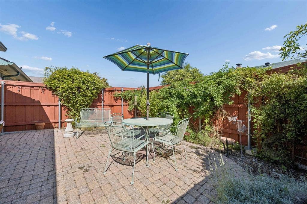 1902 Wyatt Drive, Garland, TX 75040 Paved patio area with a privacy fence, established climbing vines, and garden beds