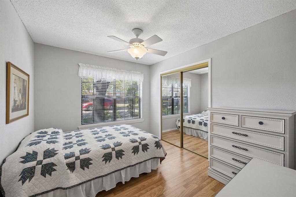 1902 Wyatt Drive, Garland, TX 75040 Wood-finish flooring, ceiling fan, window with blinds, and mirrored closet doors