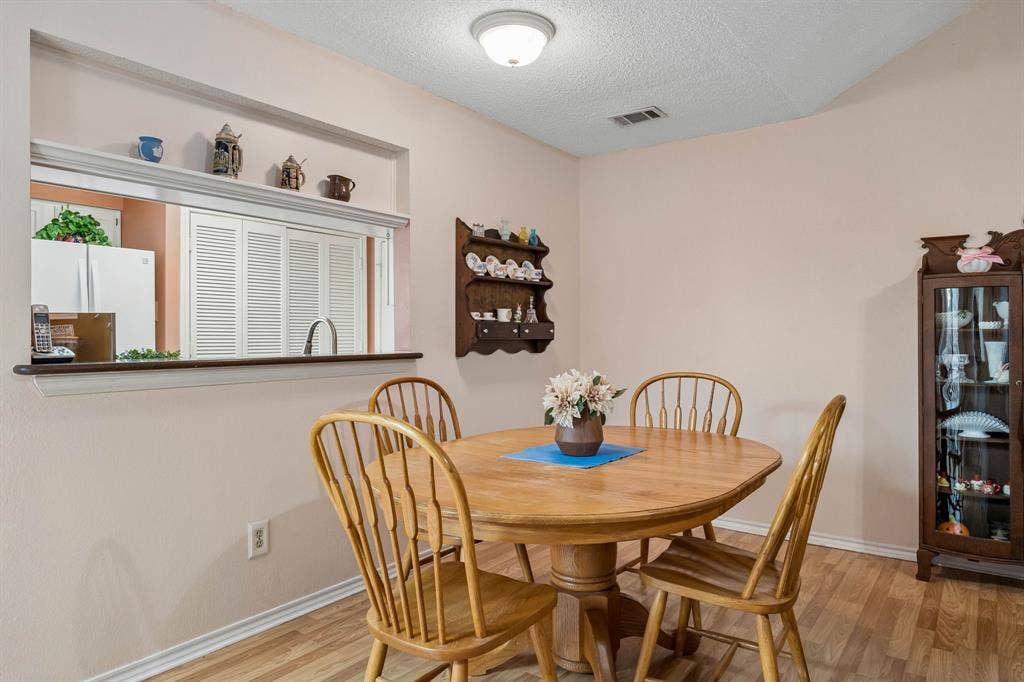 1902 Wyatt Drive, Garland, TX 75040 Wood-finish flooring with a pass-through window featuring a display shelf