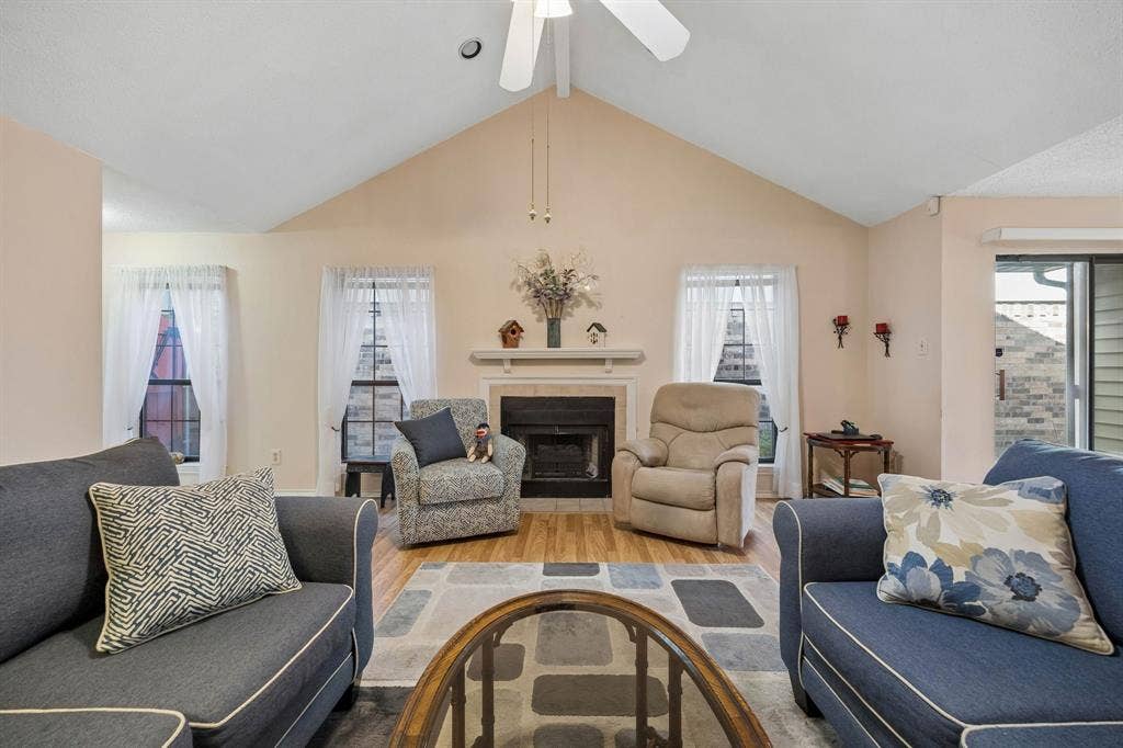1902 Wyatt Drive, Garland, TX 75040 Vaulted ceiling, ceiling fan, wood-finish flooring, fireplace with mantel, and a sliding glass door