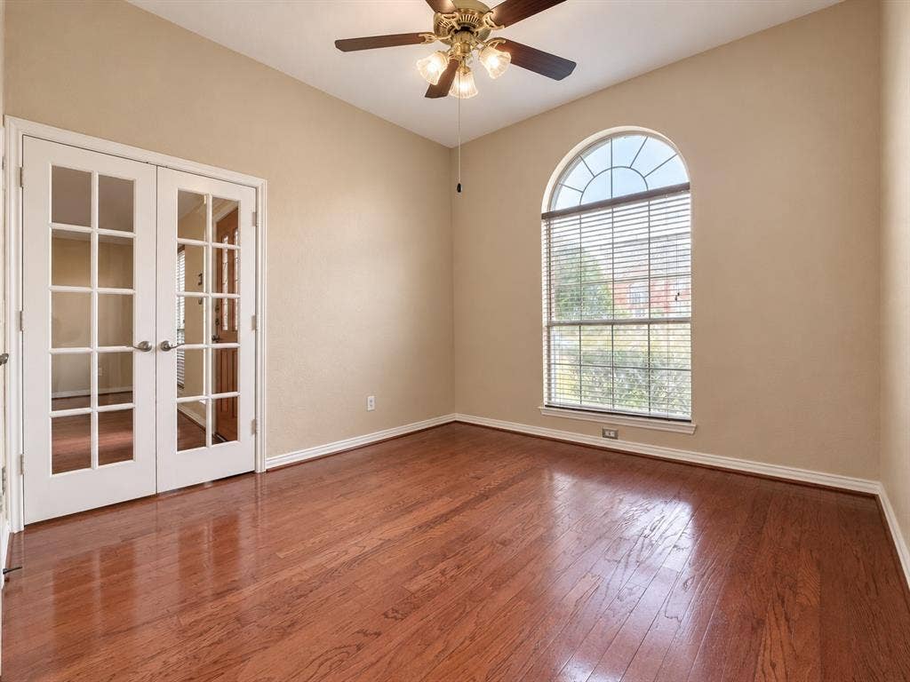 2504 Indian Paint Drive, Plano, TX 75025 Hardwood flooring, arched window with blinds, double French doors, ceiling fan with light fixture, and light-colored walls
