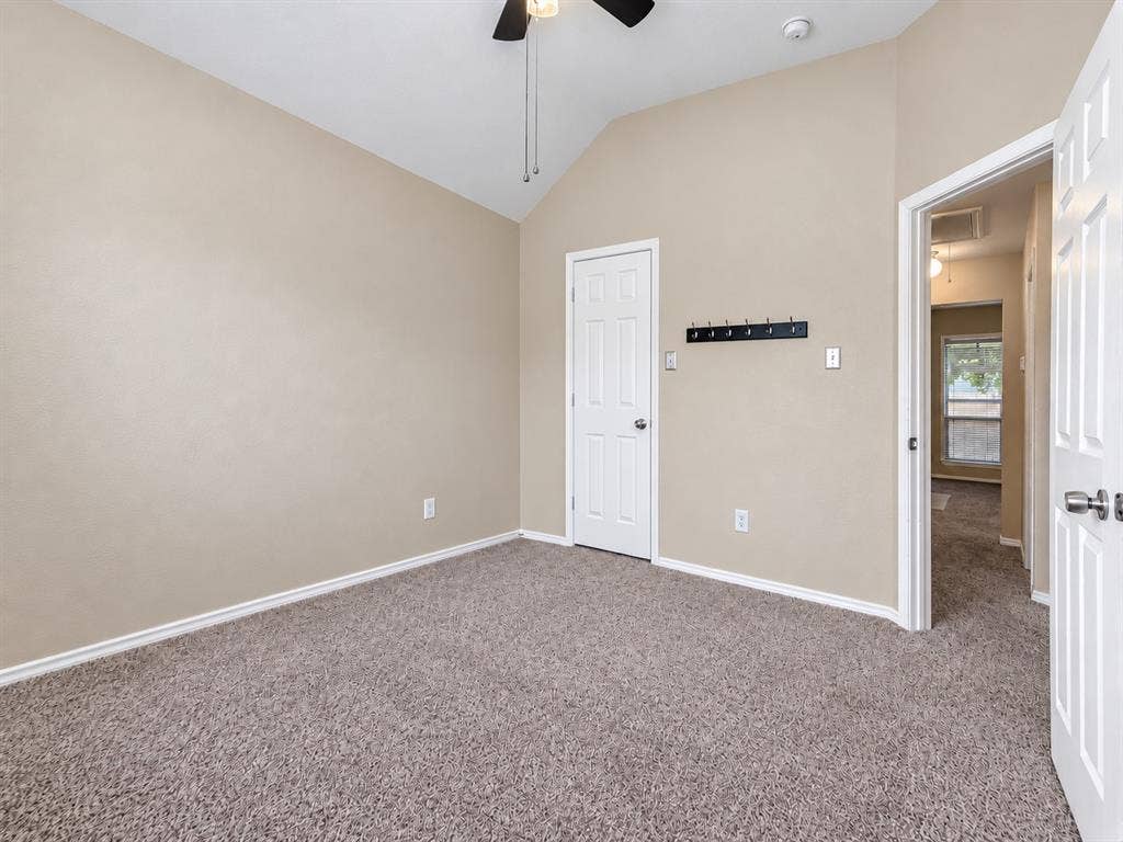 2504 Indian Paint Drive, Plano, TX 75025 Vaulted ceiling with a ceiling fan, neutral carpet flooring, and white trim