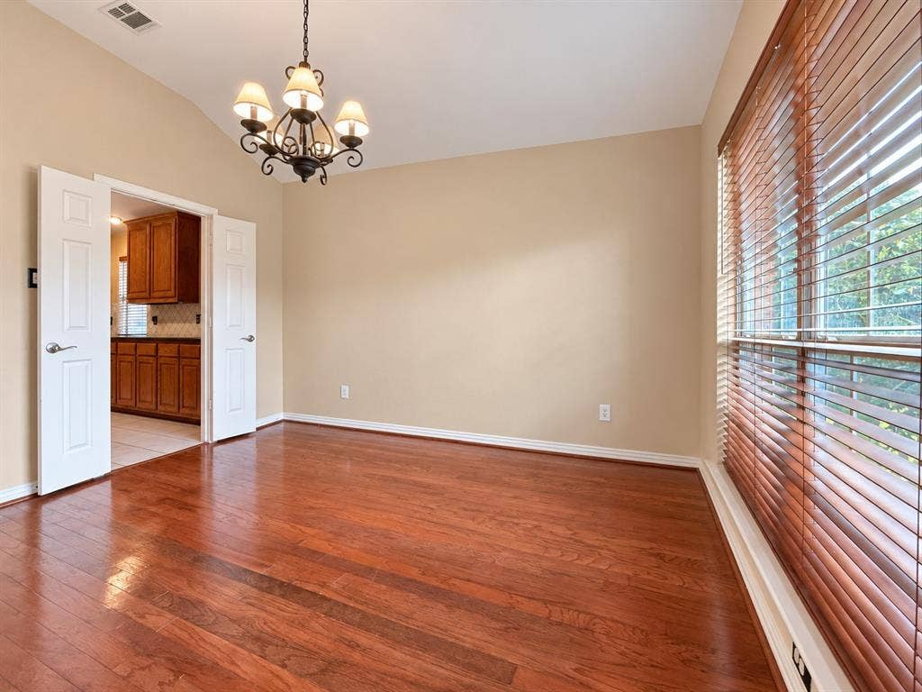 2504 Indian Paint Drive, Plano, TX 75025 Wood-finish flooring, vaulted ceiling, and a five-light chandelier