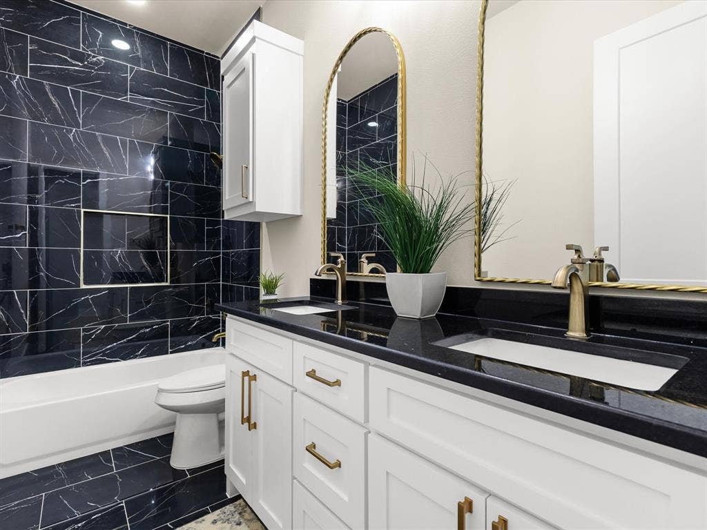 2127 Amanda Avenue, Fort Worth, TX 76105 Dual sink vanity with white cabinetry, black countertops, and gold-toned hardware