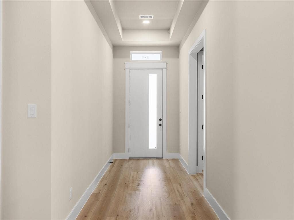 2127 Amanda Avenue, Fort Worth, TX 76105 Recessed ceiling with integrated lighting, wood-finish flooring, white solid core door with frosted glass panel, transom window, and neutral wall tones