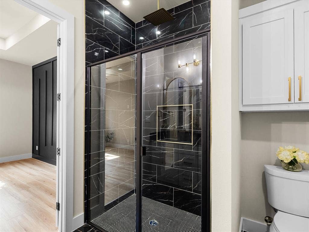 2127 Amanda Avenue, Fort Worth, TX 76105 Shower with black marble-finish tile, glass enclosure, and a gold-finish rain shower head