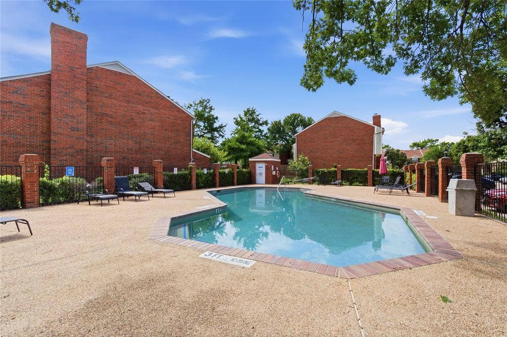212 Samuel Boulevard, #3, Coppell, TX 75019 Swimming pool with a textured concrete deck, brick coping, and a surrounding wrought iron fence with brick pillars