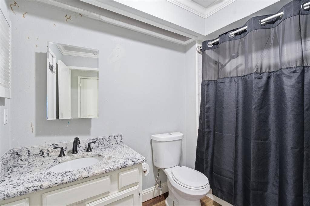 212 Samuel Boulevard, #3, Coppell, TX 75019 White vanity with stone countertop, undermount sink, and dark-finish faucet