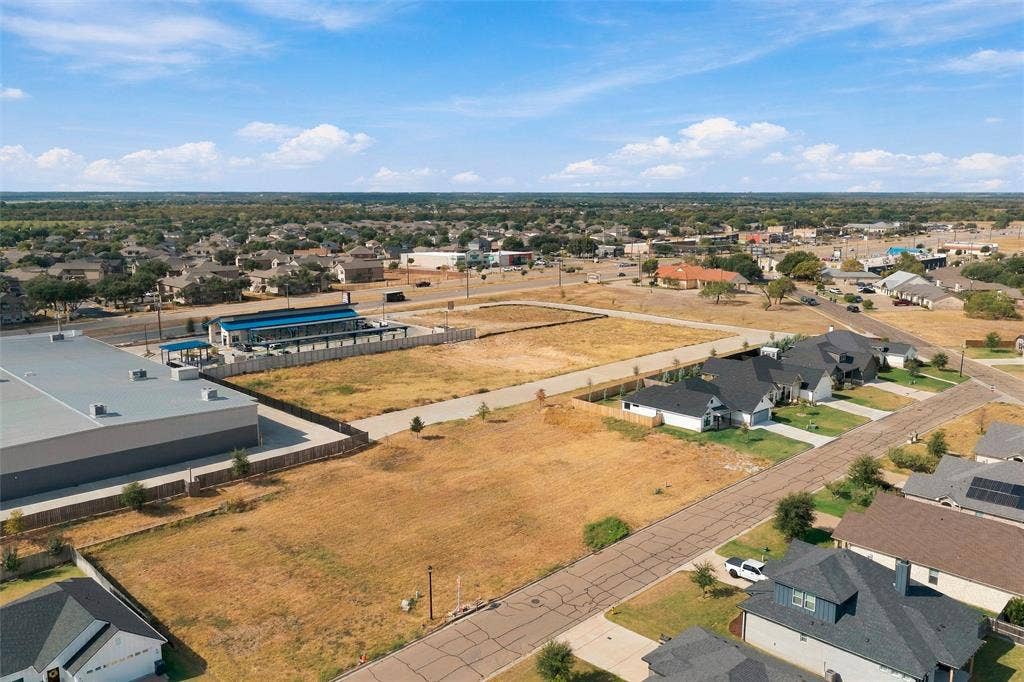 9932 Bridlewood Lane, Waco, TX 76708 Expansive open lot featuring undeveloped land and established roadways